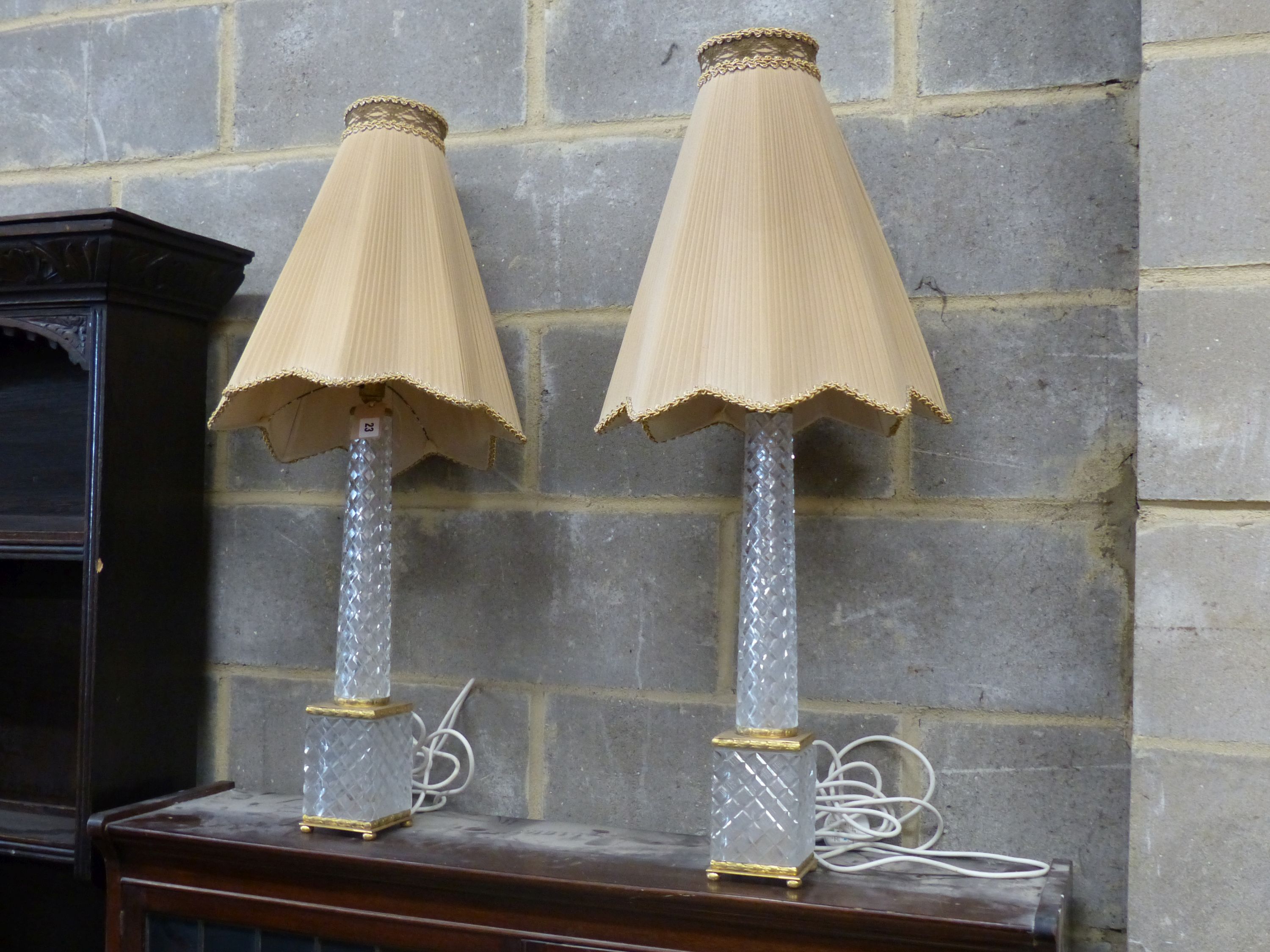 A pair of tall cut glass and gilt metal table lamps, having tapered columns and shades, height 50cm
